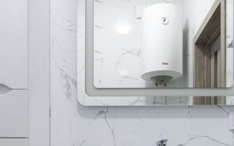 Wall mounted storage geyser installed above a bathroom washbasin